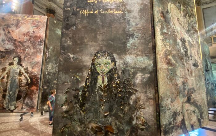 La mostra, pensata e costruita su misura per l’affascinante Sala delle Cariatidi di Palazzo Reale, è composta da 38 teleri (grandi tele montate su telai di legno) che creano uno stretto rapporto con il luogo che le accoglie e ritraggono figure femminili: le alchimiste.